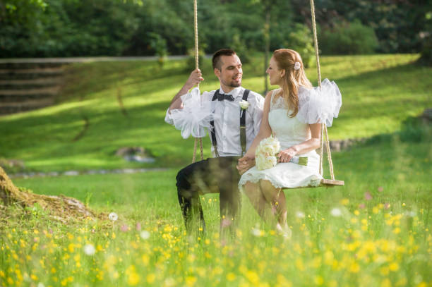istock Bride and groom sitting in park 859674548