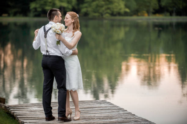istock Bride and groom standing on jetty 859674564
