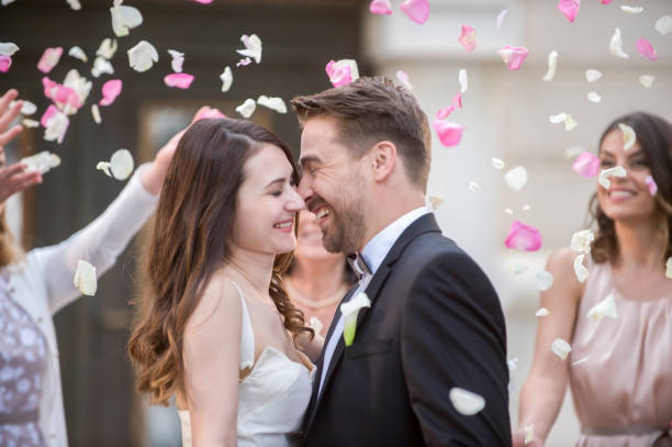 istock Friends throwing petals on wedding couple 859674572