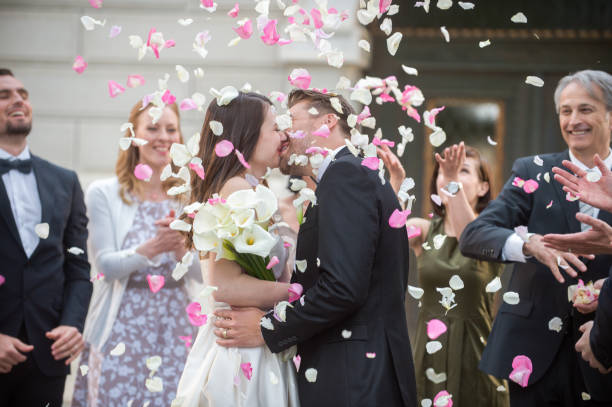 istock Friends throwing petals on wedding couple 859674630