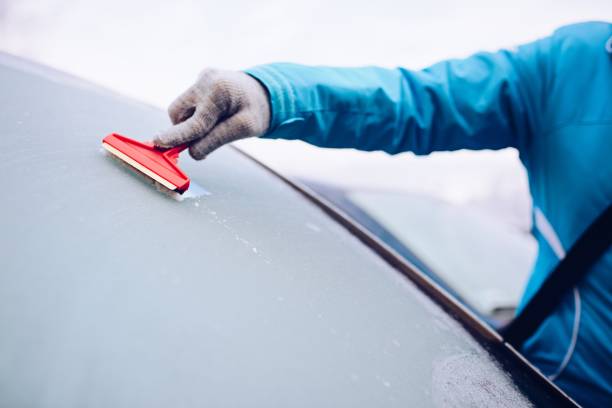 istock Woman scraping frozen front car windshield 859675174