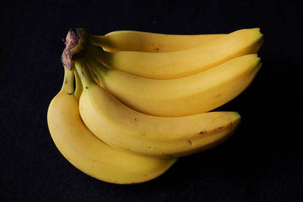 istock Bunch of bananas on black background 859676810