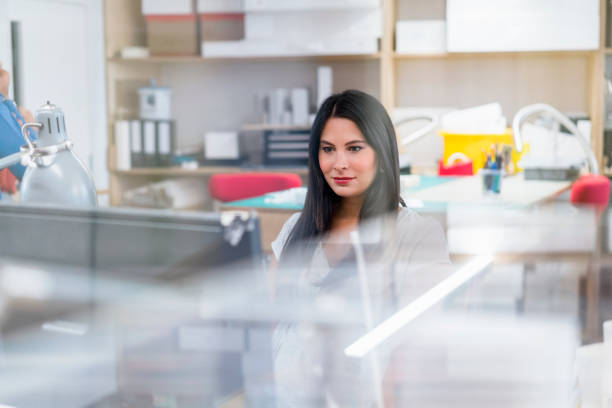Confident professional working at desk. Smiling businesswoman is having long hair. She is at creative office.