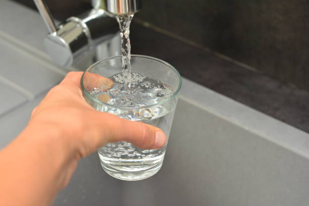 istock A woman's hand pours water into a glass 859699862