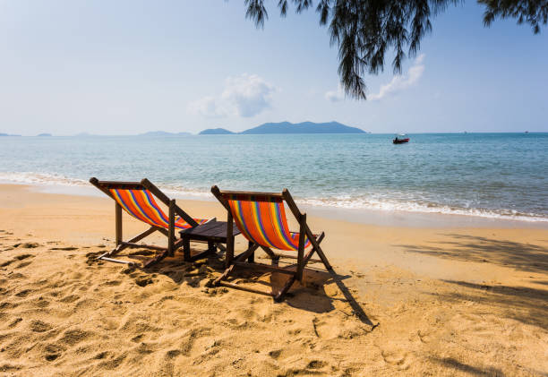 istock sun beach chairs on shore near sea. 859702492