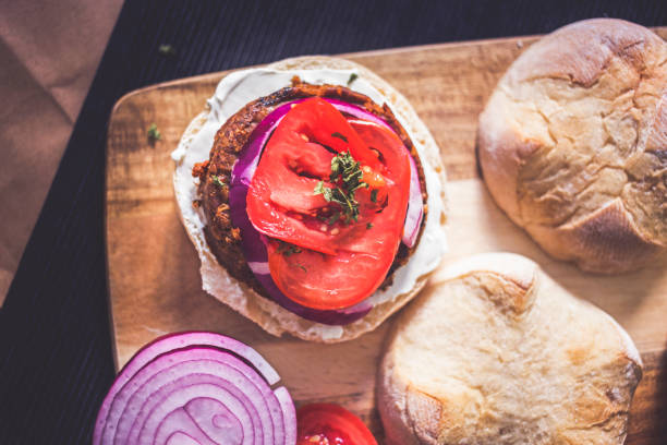 un burguer vegetariano aperto con condimenti - patty pan foto e immagini stock