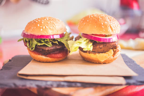 due burguer vegetariani con condimenti su una cucina di sfondo - patty pan foto e immagini stock