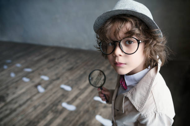 Little boy Little detective with a magnifying glass detective stock pictures, royalty-free photos & images