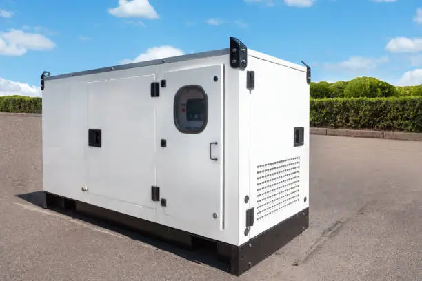 Photo of Industrial Diesel Generator. Standby generator. Industrial Diesel Generator for Office Building connected to the Control Panel with Cable Wire. Backup Generator Power.