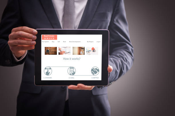istock Real Estate Agent man showing a tablet 859732282