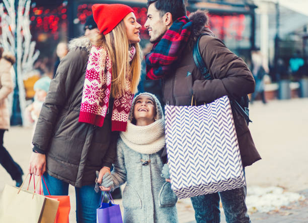 Christmas shopping Family enjoying a shopping weekend during Christmas three way kiss stock pictures, royalty-free photos & images