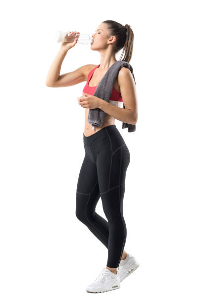 istock Tired thirsty female runner drinking water from glass bottle with head titled back. 859736530