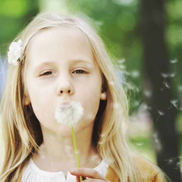istock Cute child and dandelion on greenery background 859751690
