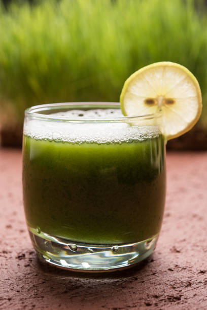 アーユルヴェーダや薬用小麦草ジュース ガラス、選択と集中でレモン スライス - wheatgrass alternative medicine detoxification juice ストックフォトと画像