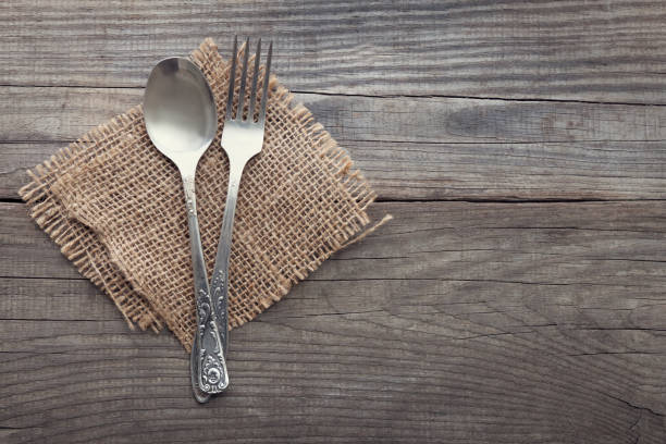 istock Old fork and spoon on a wooden table napkin and burlap, grunge rustic style, top view. 859765004