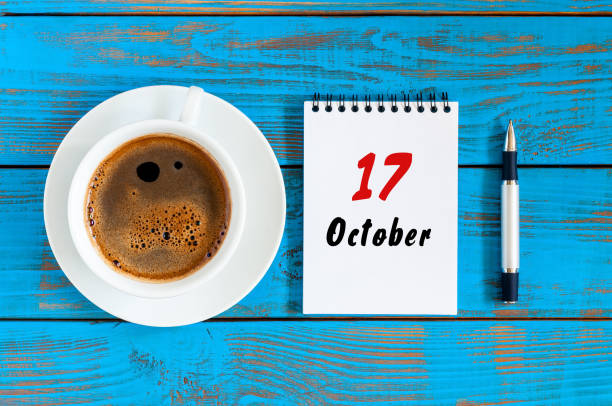 istock October 17th. Day 17 of october month, calendar on workbook with coffee cup at student workplace background. Autumn time 859779206