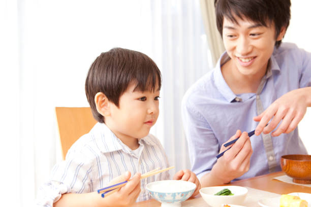 istock His father teaches how to use chopsticks and son hear it 859780152