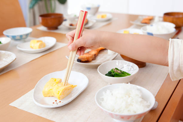 istock Girl points to the fried eggs with chopsticks in hand 859780394