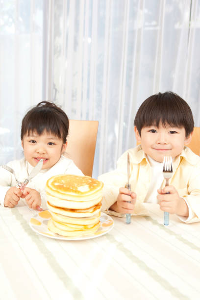 istock Boy eats Pancakes for a snack and a girl 859783786