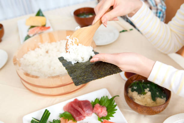 istock Local woman making hand-rolled sushi 859784530