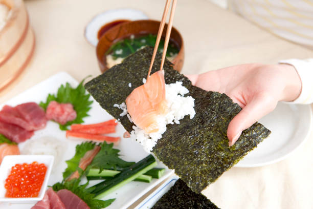 istock Local woman making hand-rolled sushi 859784556