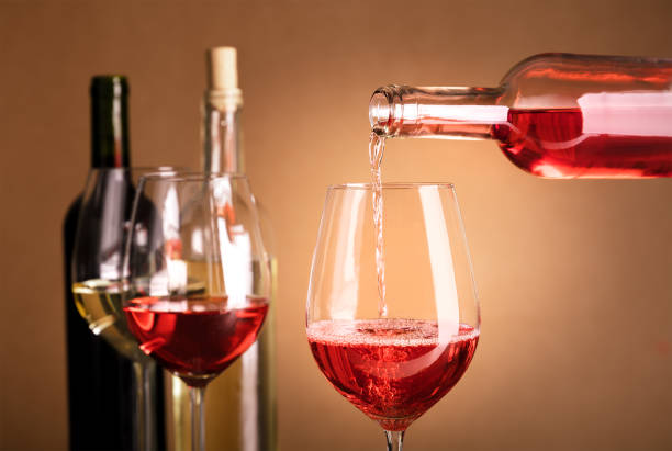 istock Rose wine poured into glass from bottle with copyspace 859787770