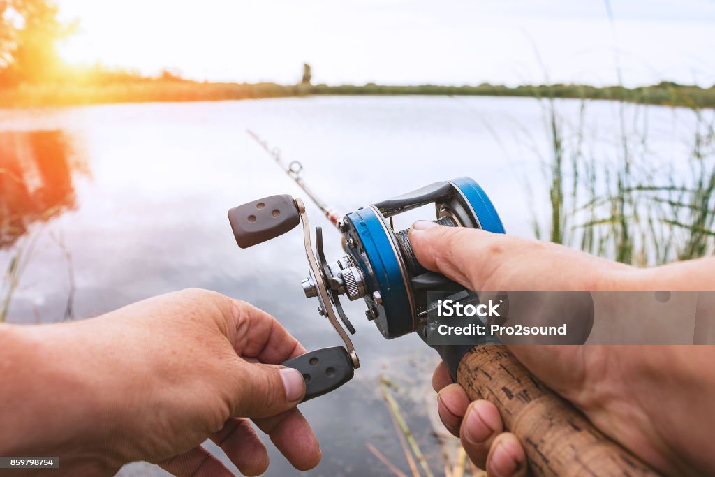 Hombre es pescar con un carrete de la retrospección - Foto de stock de Industria de la pesca libre de derechos