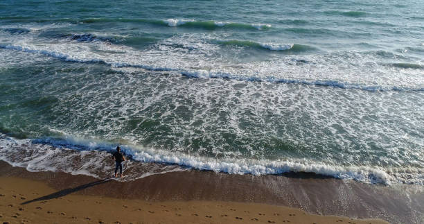 istock High angle view of man standing on the beach 859800008