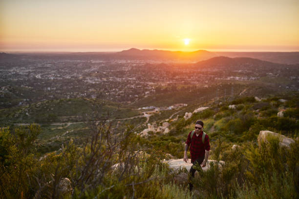 istock bearded millennial hiker walking up trail during sunset 859800102