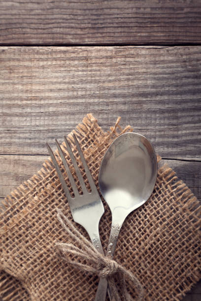 istock Old fork and spoon on a wooden table napkin and burlap, grunge rustic style, top view. 859803152