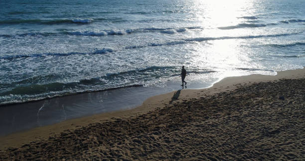 istock High angle view of man jogging on the beach 859806906