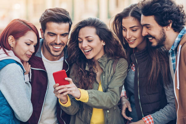 istock Group of smiling young people with smart phone 859807078
