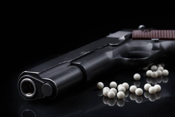 istock airsoft pistol with bb bullets on black glossy surface 859812820