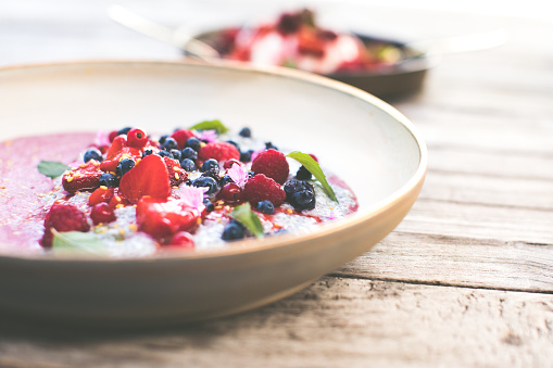 Healthy Food. Healthy Breakfast with berries, yogurt, chia, mint and flowers on a wooden background