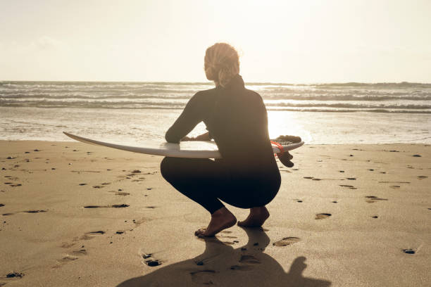istock Surfer kneeling with his surfboard on Fistral Beach, Newquay, Cornwall. 859816500