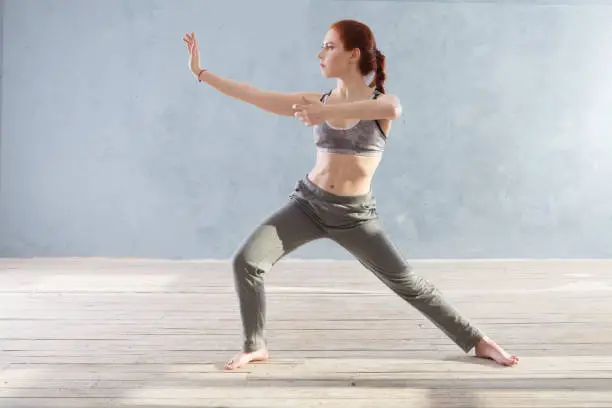 Photo of Woman praticing tai chi chuan in the gym.