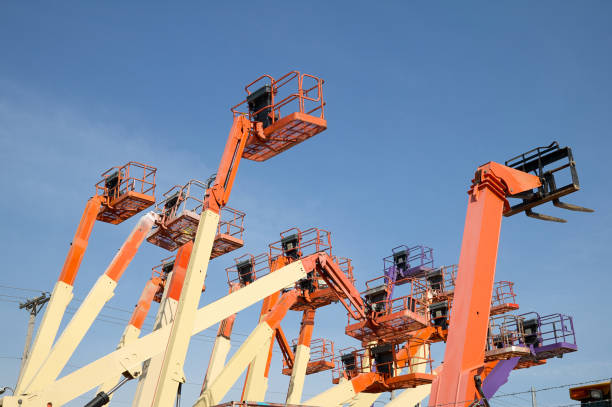 Aerial work platforms against clear blue sky stock photo