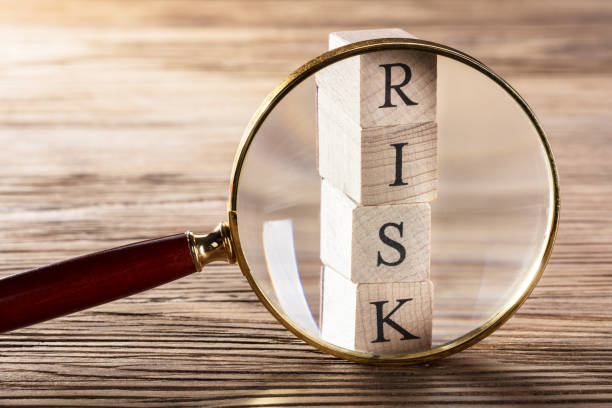 istock Person Placing Magnifying Glass Over Risk Block 859832982