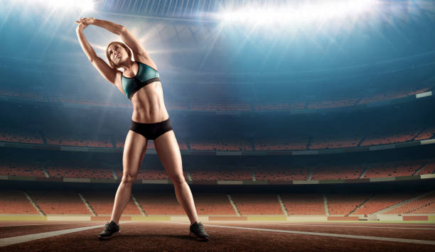 istock muscular female athlete stretching on stadium with running track 859833086