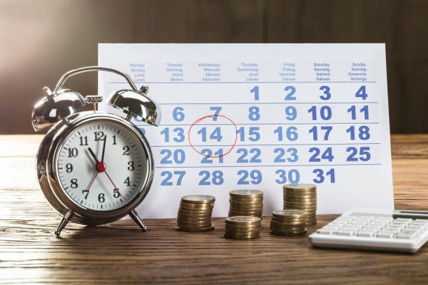 istock Tax Time On Alarm Clock With Coins 859833156