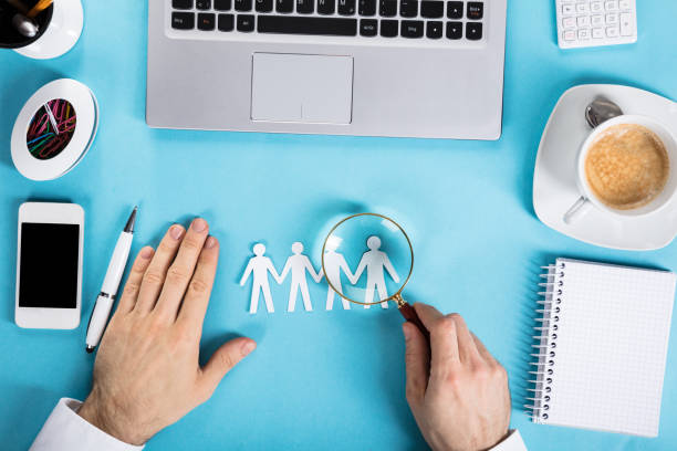 istock Businessman Magnifying The Paper Cut Out Human Figure 859833442