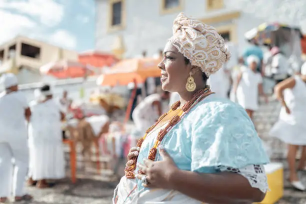 baiana in traditional costume in front of Sao Lazaro church in Salvador