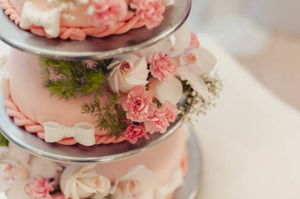 istock Beautiful white and colored wedding cake. A bride and a groom is cutting their wedding cake 859837228