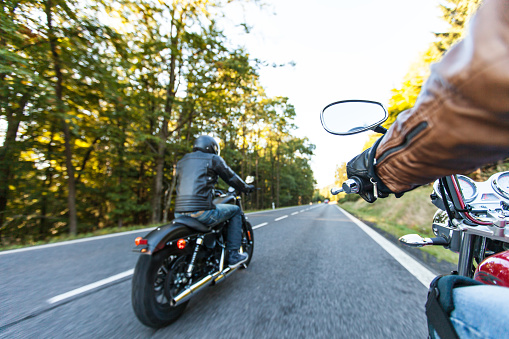 Asiento del hombre en la motocicleta en la carretera del bosque photo