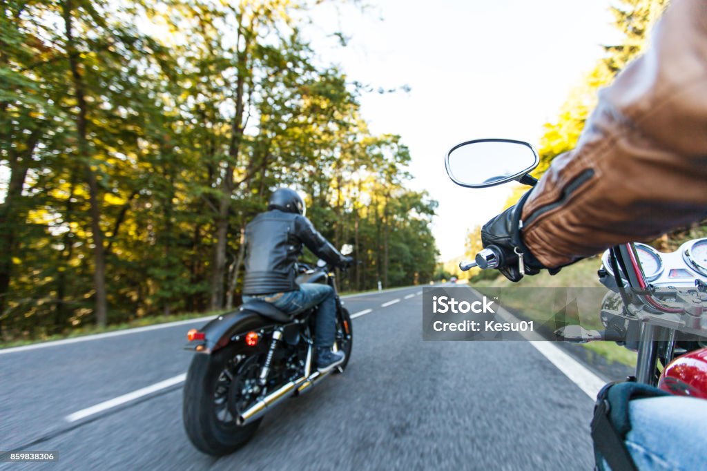 Man seat on the motorcycle on the forest road Man seat on the motorcycle on the forest road during sunrise. Motorcycle Stock Photo