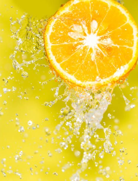 istock orange in water on a yellow background background 859848480
