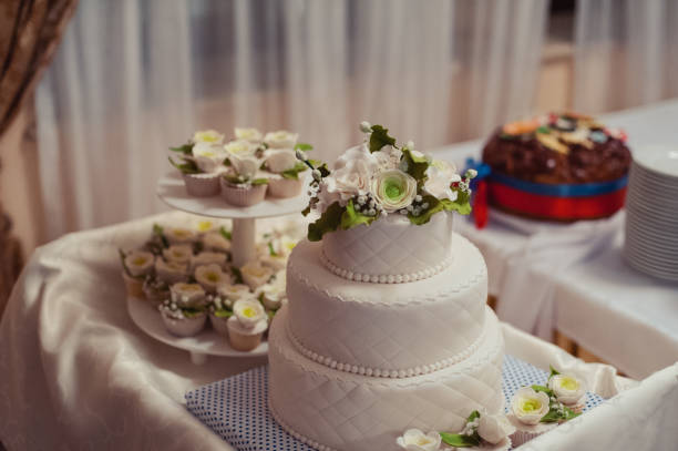 istock Beautiful white and colored wedding cake. A bride and a groom is cutting their wedding cake 859849604