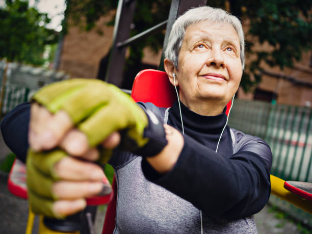 istock Senior woman trains on exercise machine in public park 859852080