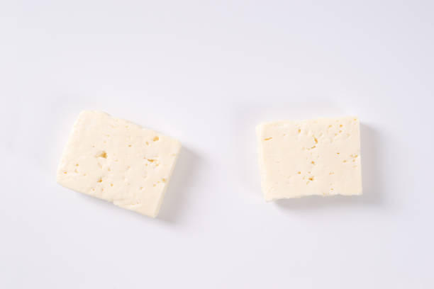 fresh feta cheese two pieces of fresh feta cheese on white background feta cheese block stock pictures, royalty-free photos & images