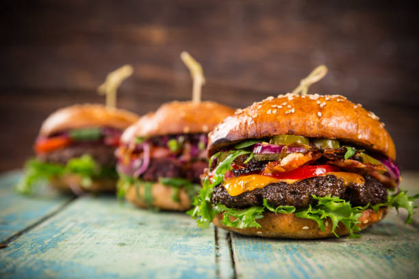 istock Tasty burgers on wooden table 859863586